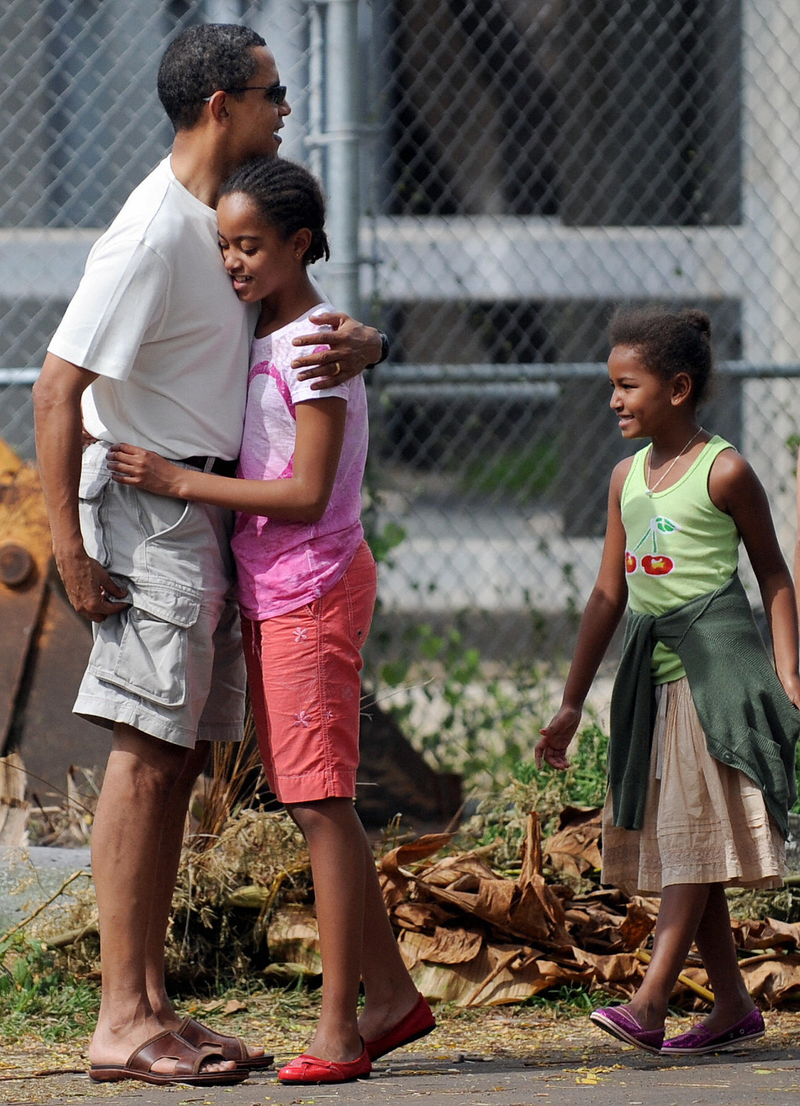 Then-President-elect Barack Obama gets a big hug from daughter Malia, followed by daughter Sasha, as they meet at the Honolulu Zoo on Dec. 30, 2008. TIM SLOAN/AFP/Getty Images